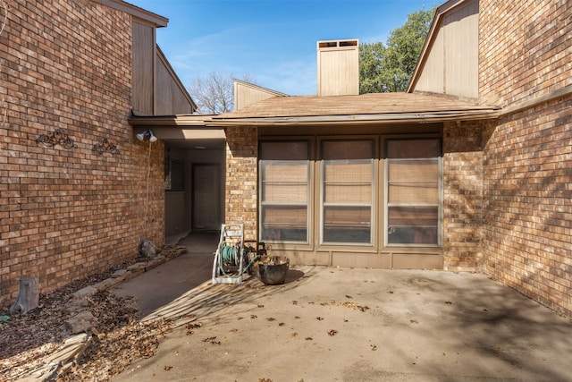 view of exterior entry featuring a patio