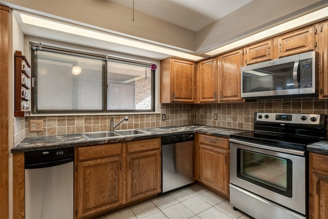 kitchen with tasteful backsplash, stainless steel appliances, sink, and light tile patterned floors