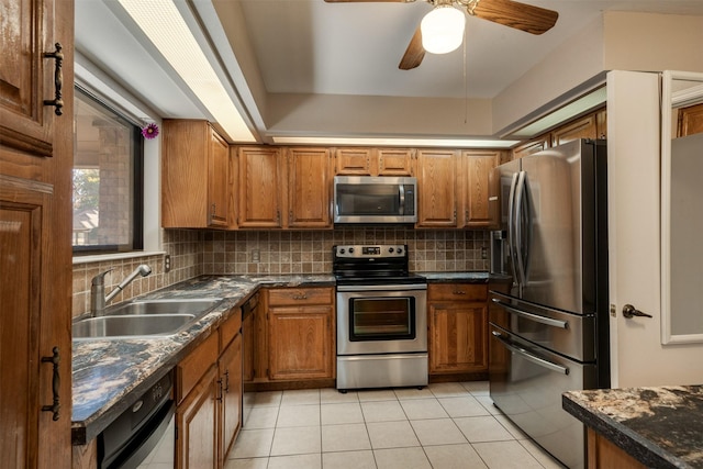 kitchen featuring sink, decorative backsplash, light tile patterned floors, and appliances with stainless steel finishes