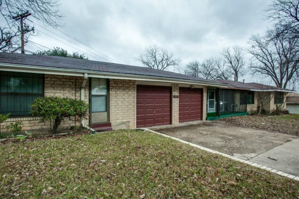 single story home with a garage and a front lawn