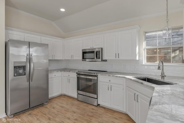 kitchen with pendant lighting, sink, white cabinets, light stone counters, and stainless steel appliances