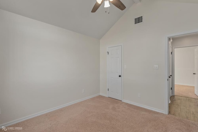 spare room with ceiling fan, beam ceiling, high vaulted ceiling, and light carpet