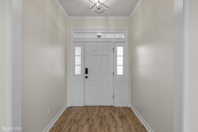 foyer featuring an inviting chandelier, hardwood / wood-style flooring, and ornamental molding