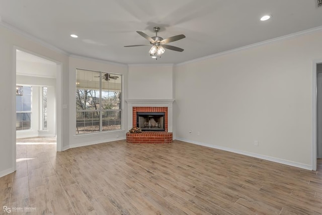 unfurnished living room featuring ornamental molding, a brick fireplace, and light hardwood / wood-style floors