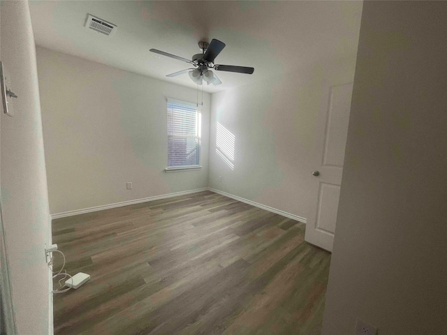 spare room with ceiling fan and dark hardwood / wood-style floors