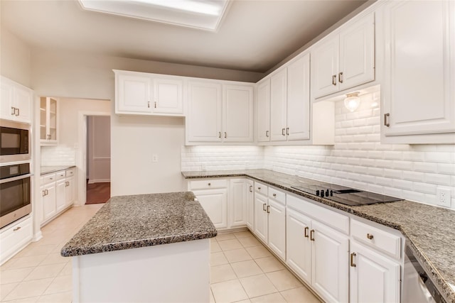 kitchen with a kitchen island, built in microwave, white cabinetry, oven, and black electric cooktop