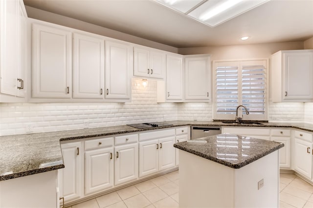 kitchen with a center island, sink, dark stone countertops, and white cabinets