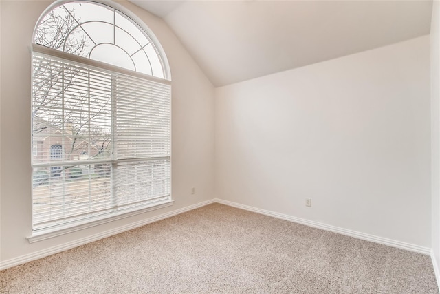 empty room featuring vaulted ceiling and carpet floors