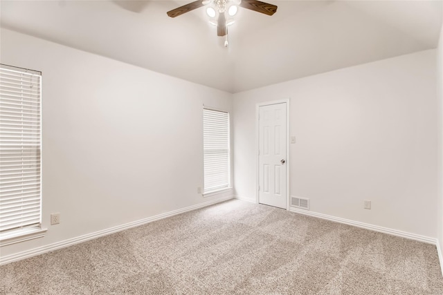 spare room featuring carpet floors, ceiling fan, and vaulted ceiling