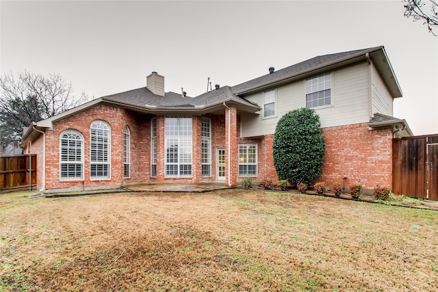 back of property with a patio and a yard