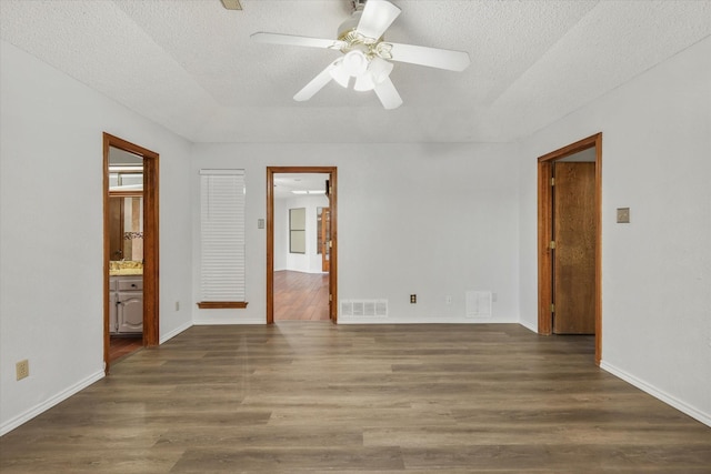 spare room with dark hardwood / wood-style floors, ceiling fan, and a textured ceiling