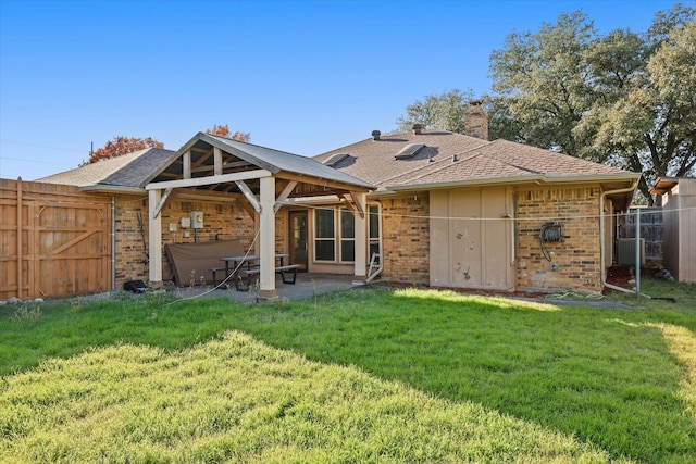 rear view of property with a yard and a patio area