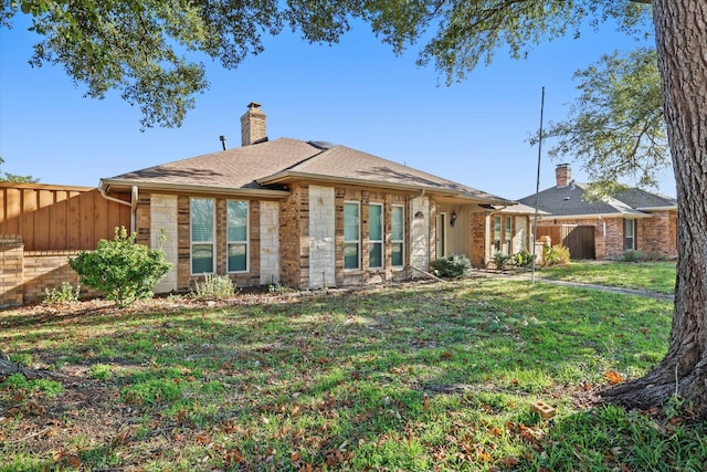 rear view of house featuring a lawn