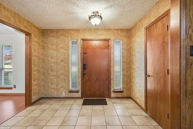 tiled foyer entrance with a textured ceiling