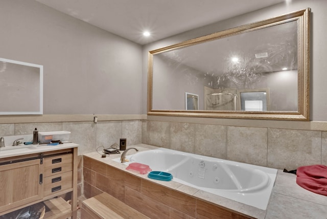 bathroom featuring vanity and a relaxing tiled tub