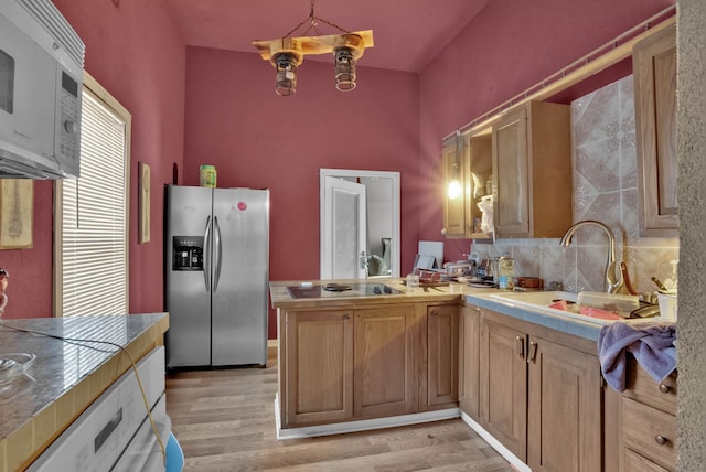 kitchen featuring pendant lighting, white appliances, sink, tile counters, and light hardwood / wood-style floors