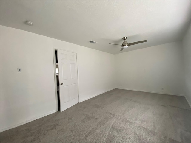 carpeted spare room featuring ceiling fan