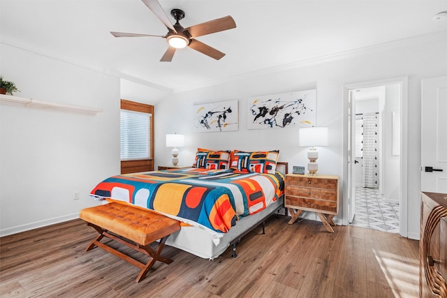 bedroom featuring wood finished floors, a ceiling fan, ornamental molding, and baseboards