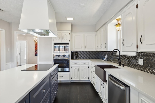 kitchen with backsplash, a textured ceiling, custom range hood, white cabinetry, and stainless steel appliances