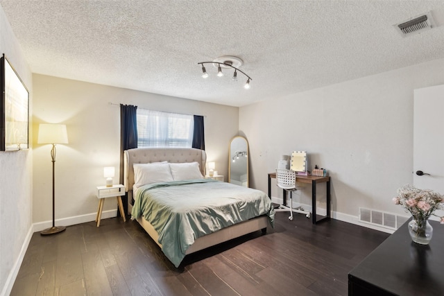 bedroom featuring a textured ceiling and dark hardwood / wood-style floors