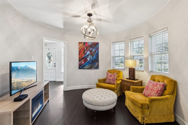 living area featuring a notable chandelier and dark hardwood / wood-style flooring