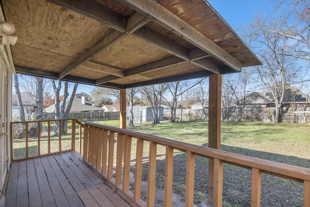 deck featuring a storage shed and a lawn