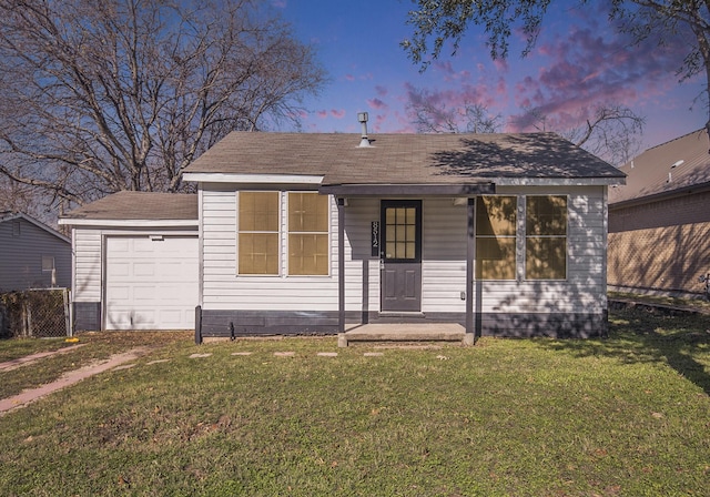 view of front of property featuring a lawn, covered porch, and a garage