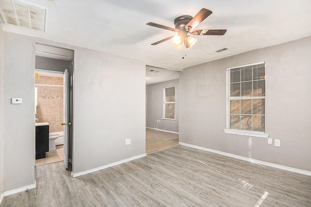 spare room with ceiling fan and light wood-type flooring