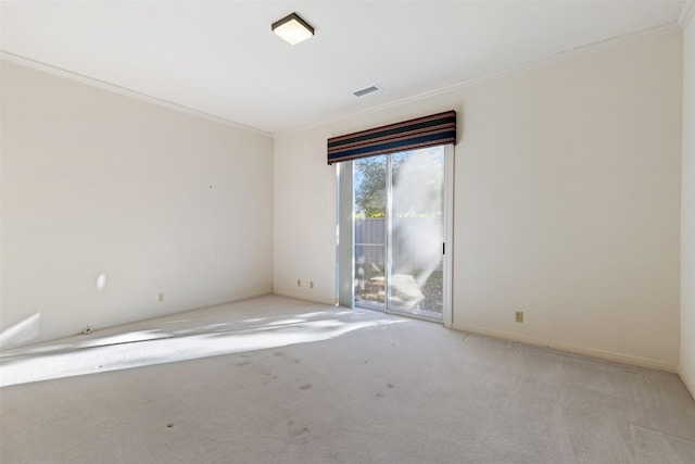 carpeted spare room featuring crown molding