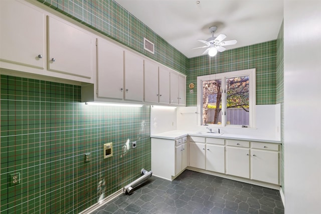 laundry area with sink, dark tile patterned flooring, cabinets, ceiling fan, and electric dryer hookup