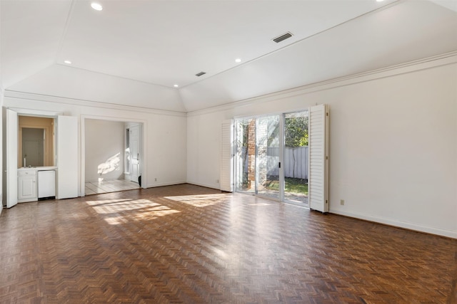 spare room featuring vaulted ceiling and dark parquet floors