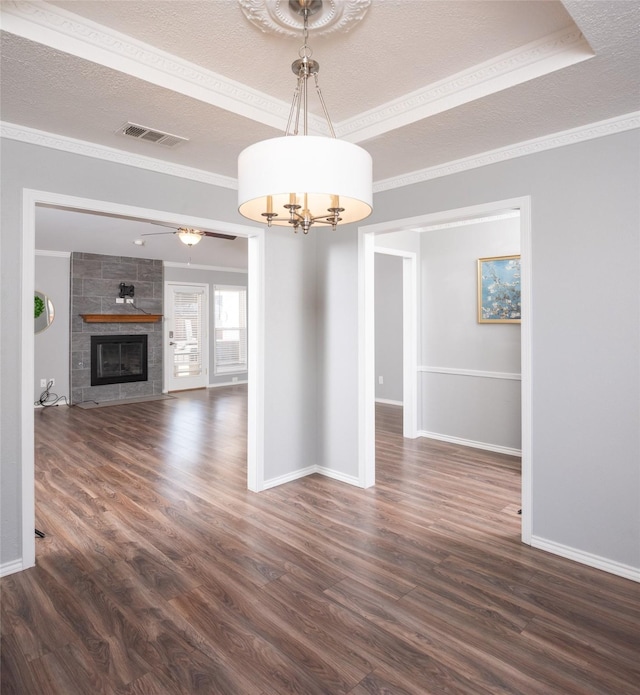 unfurnished dining area with dark hardwood / wood-style flooring, crown molding, and a textured ceiling