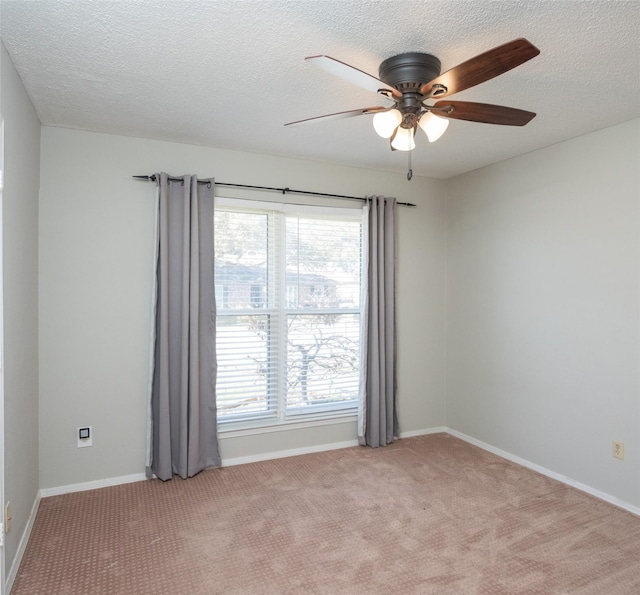 carpeted spare room featuring ceiling fan and a textured ceiling