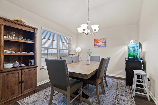 dining room with dark hardwood / wood-style flooring and an inviting chandelier