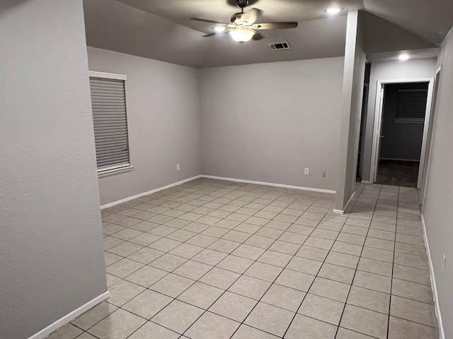 spare room with light tile patterned floors, vaulted ceiling, and ceiling fan