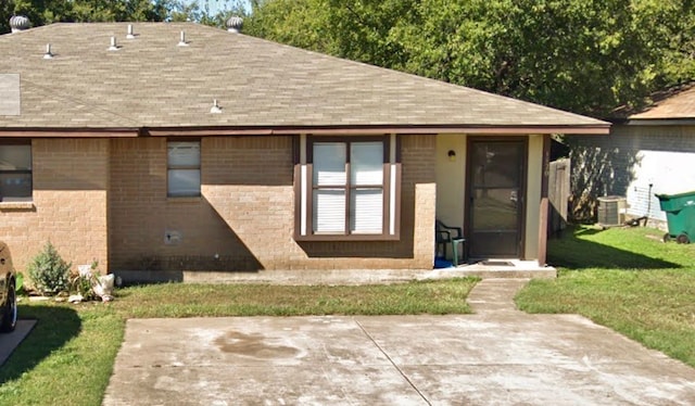 rear view of house with a lawn, central AC, and a patio