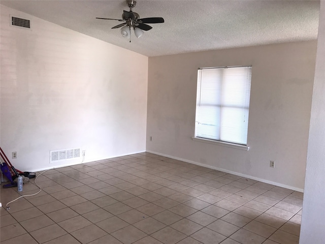 tiled spare room with ceiling fan and a textured ceiling