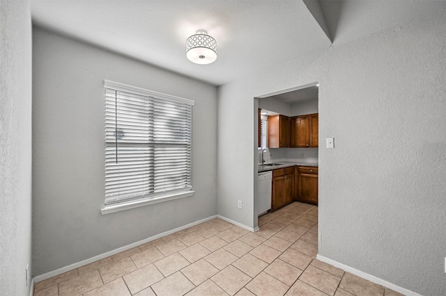 kitchen featuring light tile patterned flooring, sink, and white dishwasher