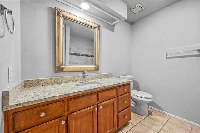 bathroom with tile patterned flooring, vanity, and toilet