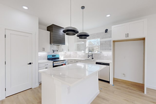 kitchen featuring white cabinets, decorative light fixtures, a kitchen island, and stainless steel appliances