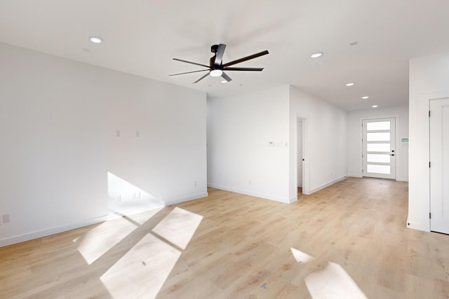 empty room with ceiling fan and light hardwood / wood-style flooring