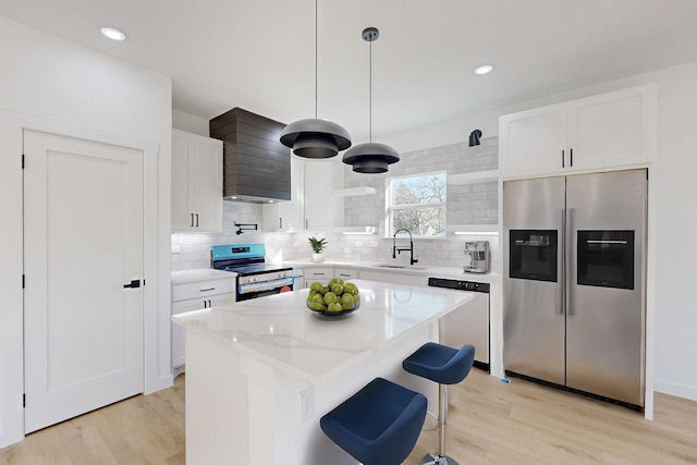 kitchen with pendant lighting, a center island, sink, appliances with stainless steel finishes, and white cabinetry