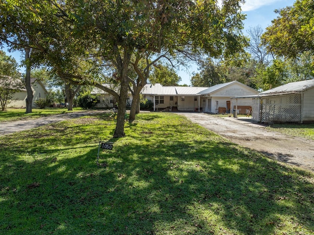 ranch-style house featuring a front lawn and a carport