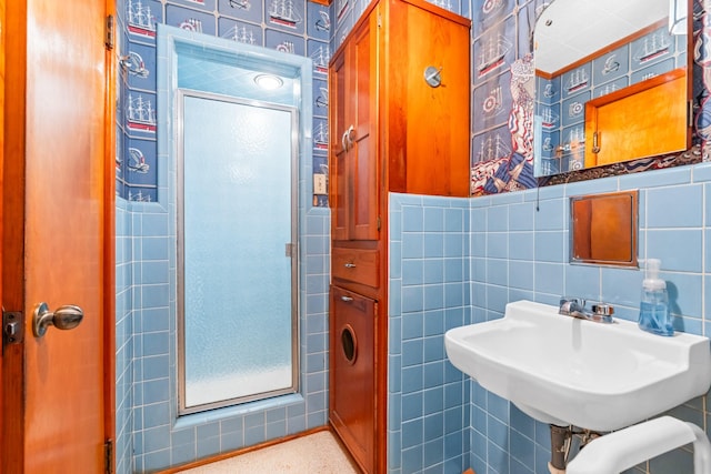 bathroom featuring sink, an enclosed shower, and tile walls