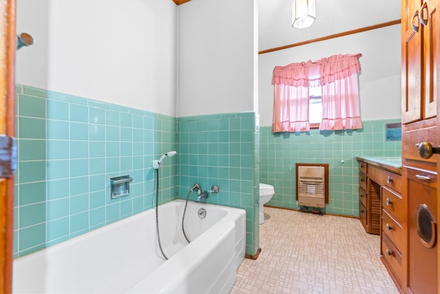 bathroom featuring a bath, heating unit, toilet, vanity, and tile walls