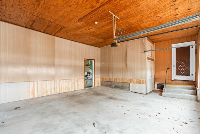 garage featuring wooden walls, wooden ceiling, and a garage door opener