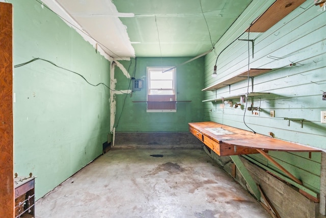 basement with a workshop area and wood walls