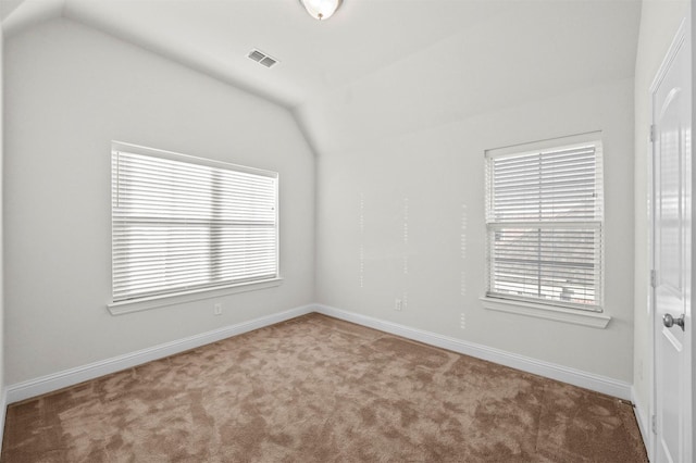 empty room with carpet flooring and vaulted ceiling