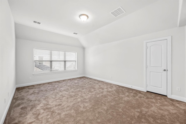 empty room featuring vaulted ceiling and carpet flooring