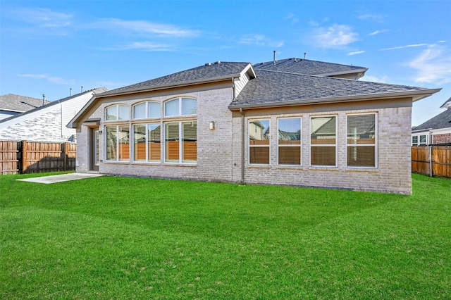 rear view of house featuring a lawn